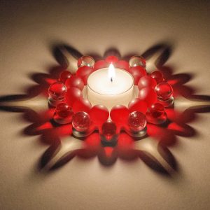 Dresdner Glasperlenstern Weihnachtsstern Zwölfer Rot Teelichthalter handgefertigt in der Dresdner Manufaktur aus Porzellan mit böhmischem Glas im Kerzenlicht
